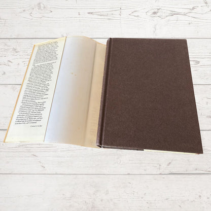Open book with a brown cover on a light wooden surface