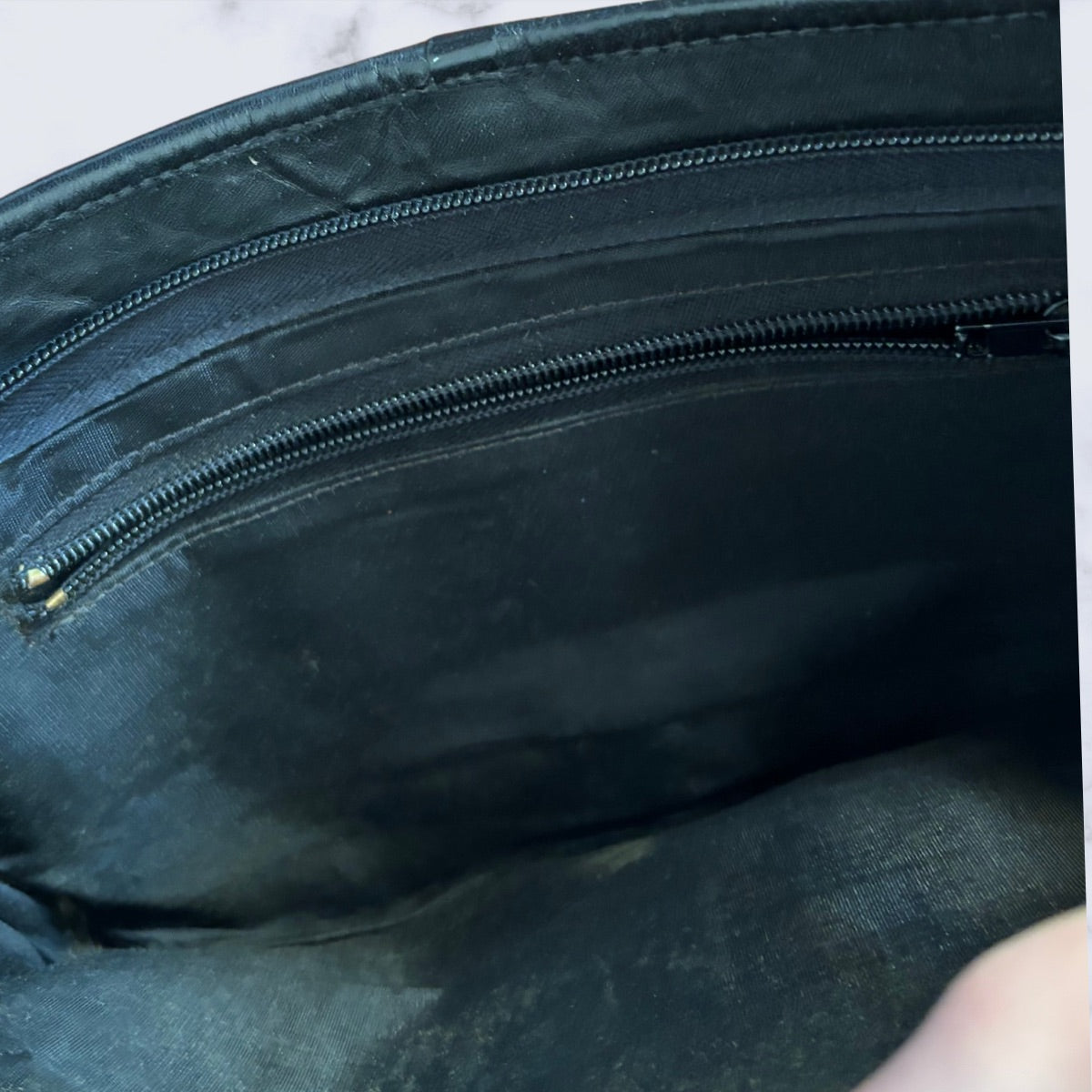 Close-up of a black leather bag with a zipper