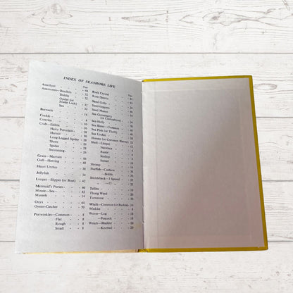 Open book with an index on a wooden surface