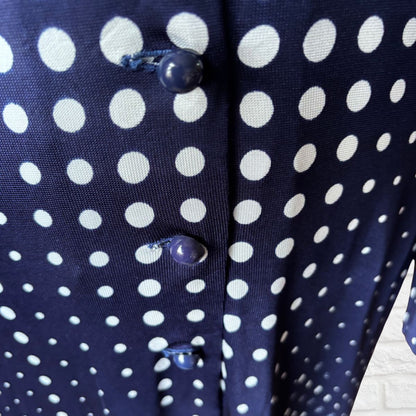 Navy blue fabric with white polka dots and buttons on a wooden surface