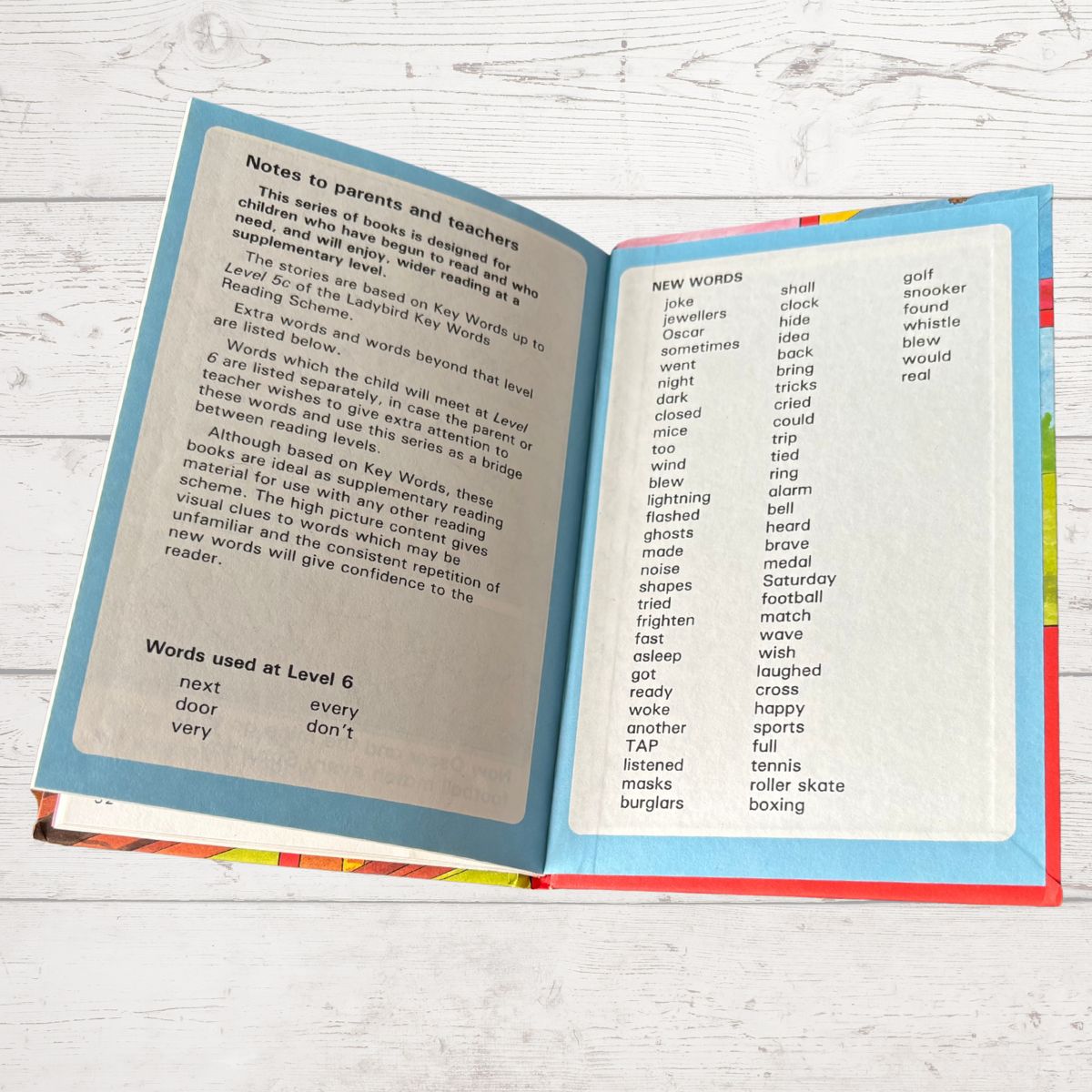 Open book showing educational content on a wooden surface