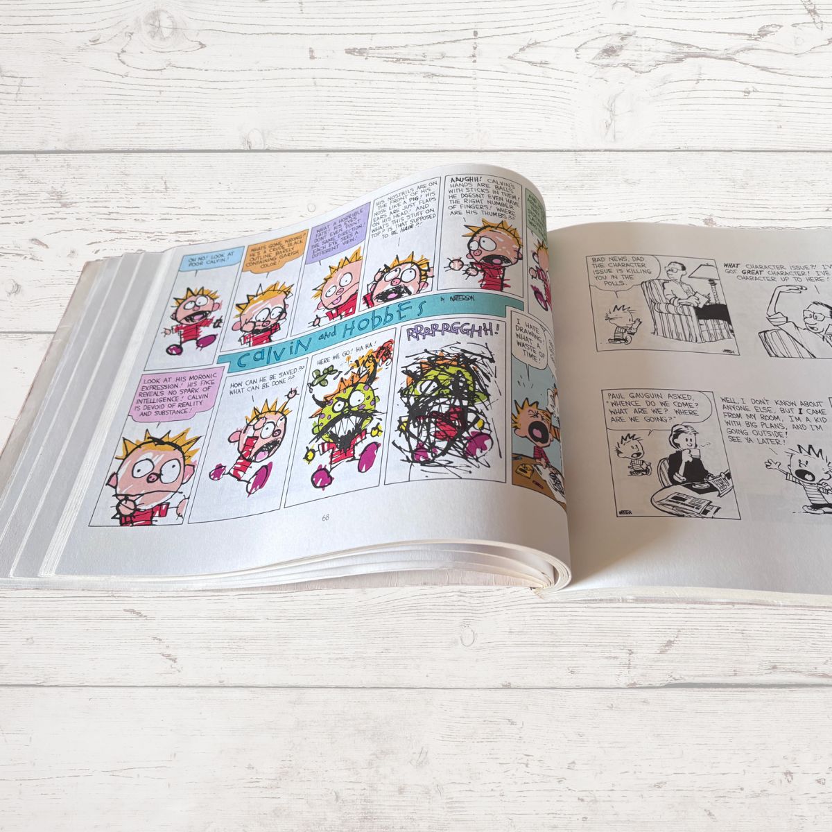 Open comic book with colorful panels on a light wooden surface