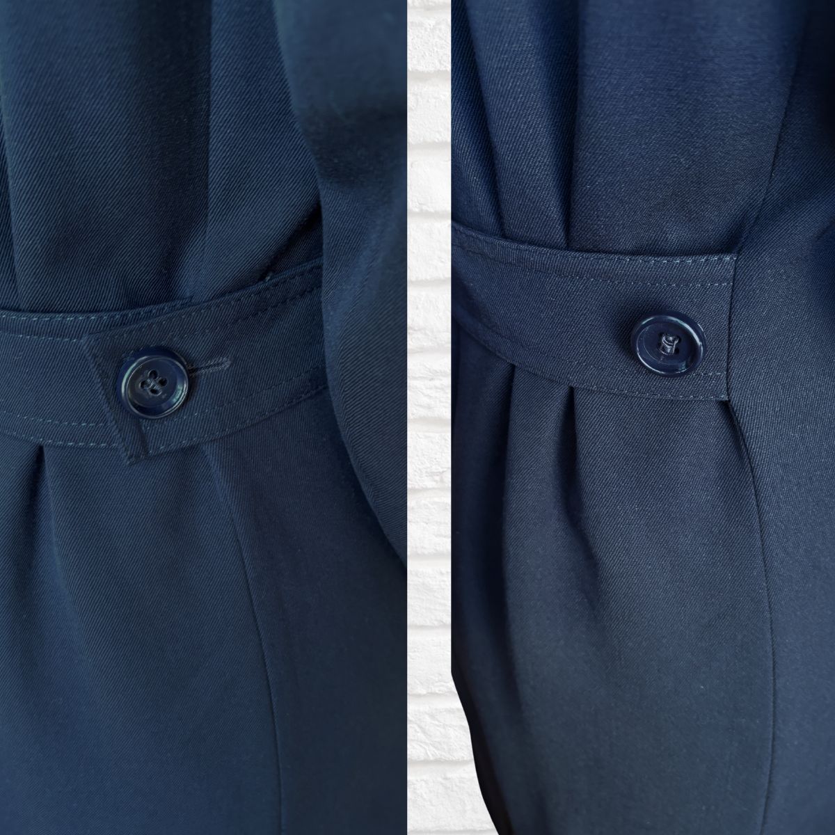 Close-up of a navy blue coat with a button detail on a white background