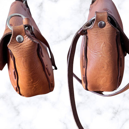 Tooled leather shoulder bag on a white background / side view 