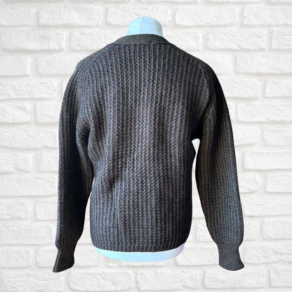 Dark brown  knitted sweater on a mannequin against a white brick wall background