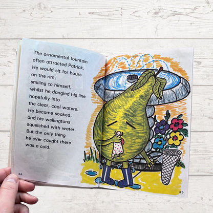 Open book with a colorful illustration of a pear character near a fountain on a wooden surface.