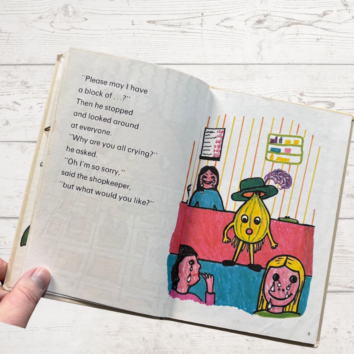 Open book with colorful illustrations and text on a wooden surface