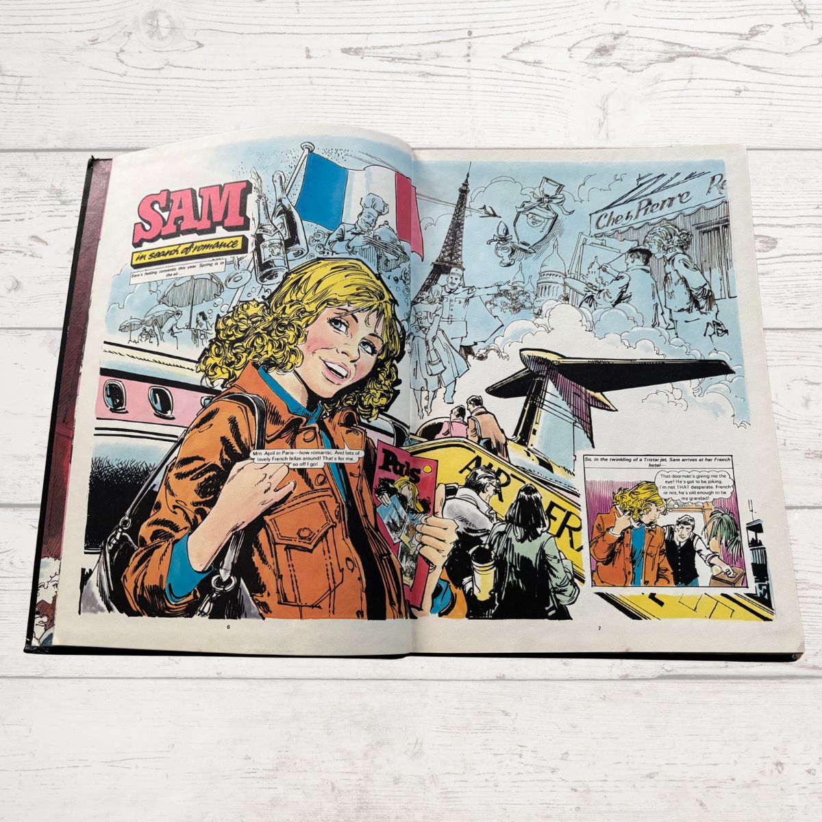 Open comic book with colorful illustrations on a wooden surface