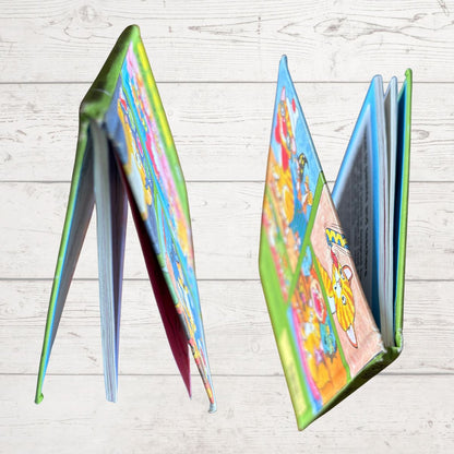 Colorful children's book spine open to a page with cartoon characters on a light wooden surface.