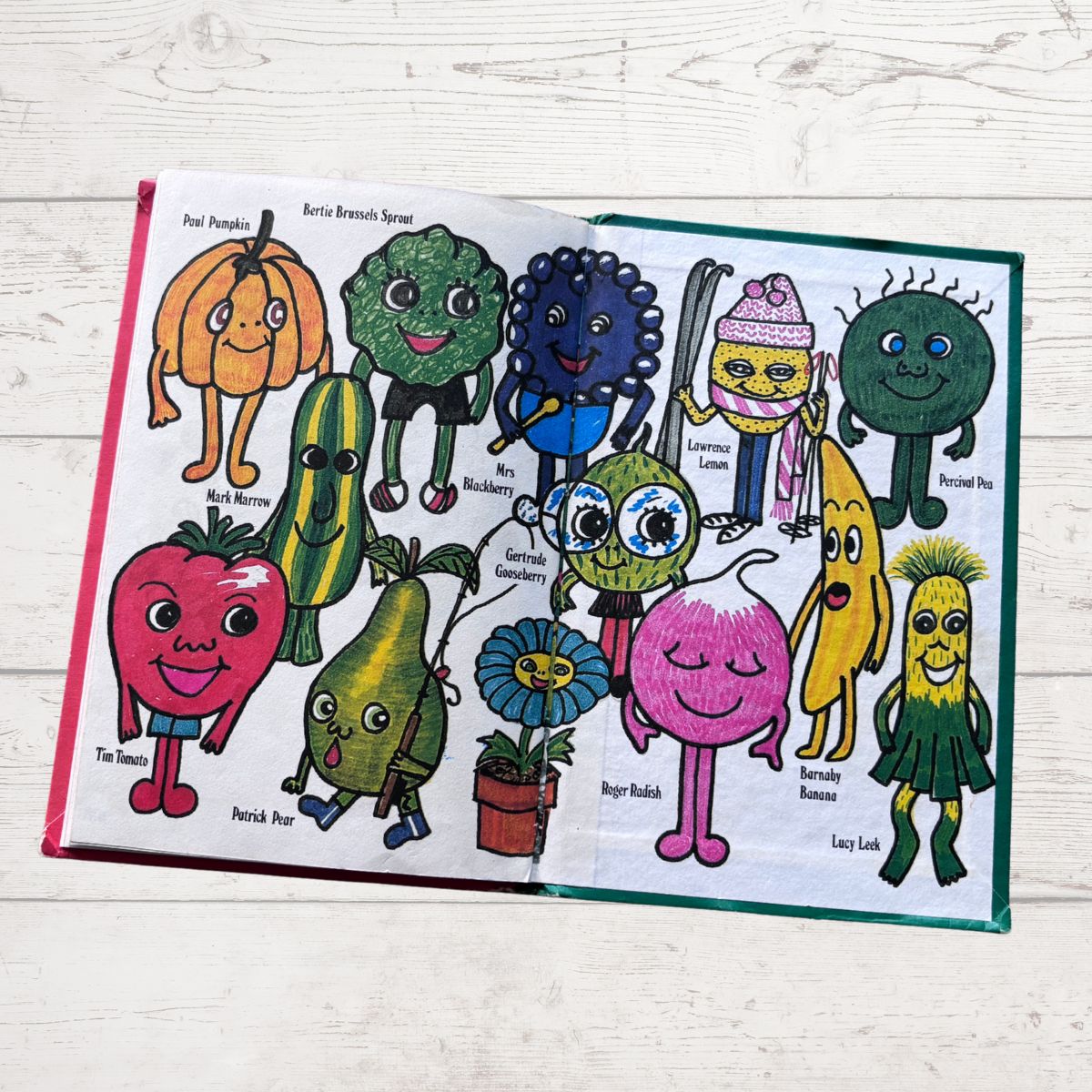 Colorful children's book open to a page with cartoon vegetable characters on a wooden surface.