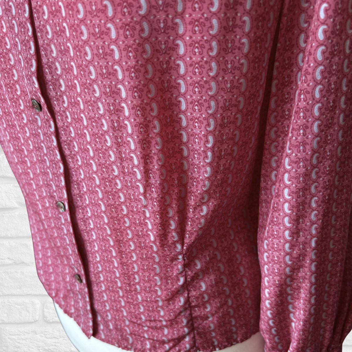 Close-up of a pink patterned handmade vintage  shirt with a white background