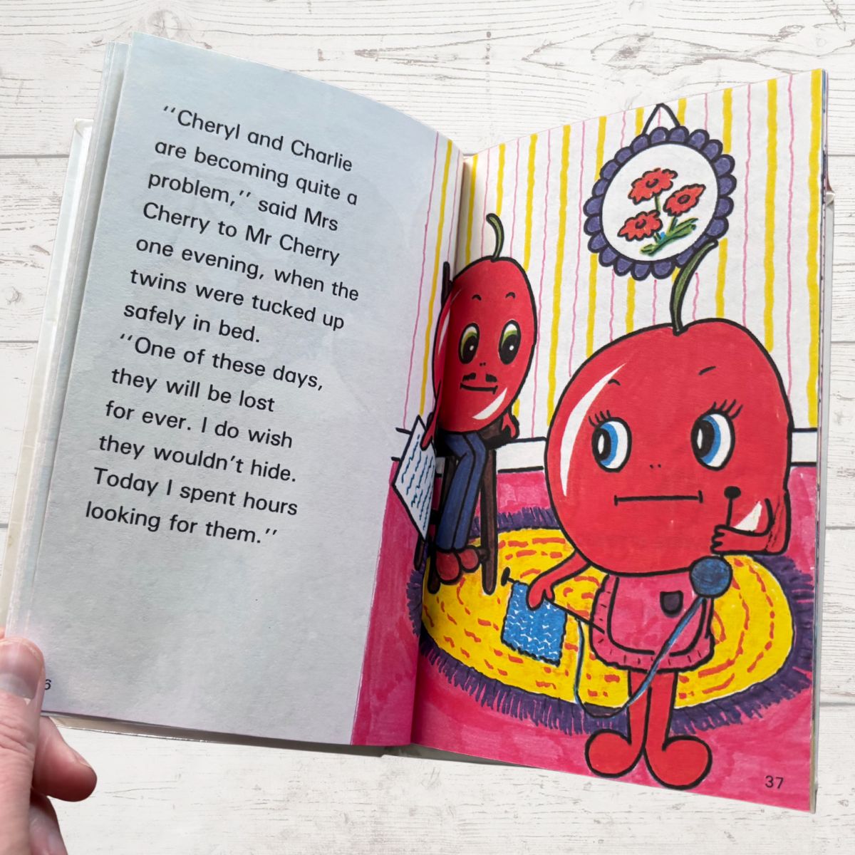 Open book with colorful illustrations of two red characters and text on a white background