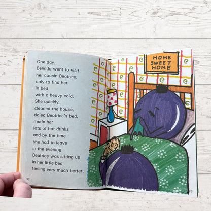 Illustrated book open to a page with text and a scene of two characters in a room.