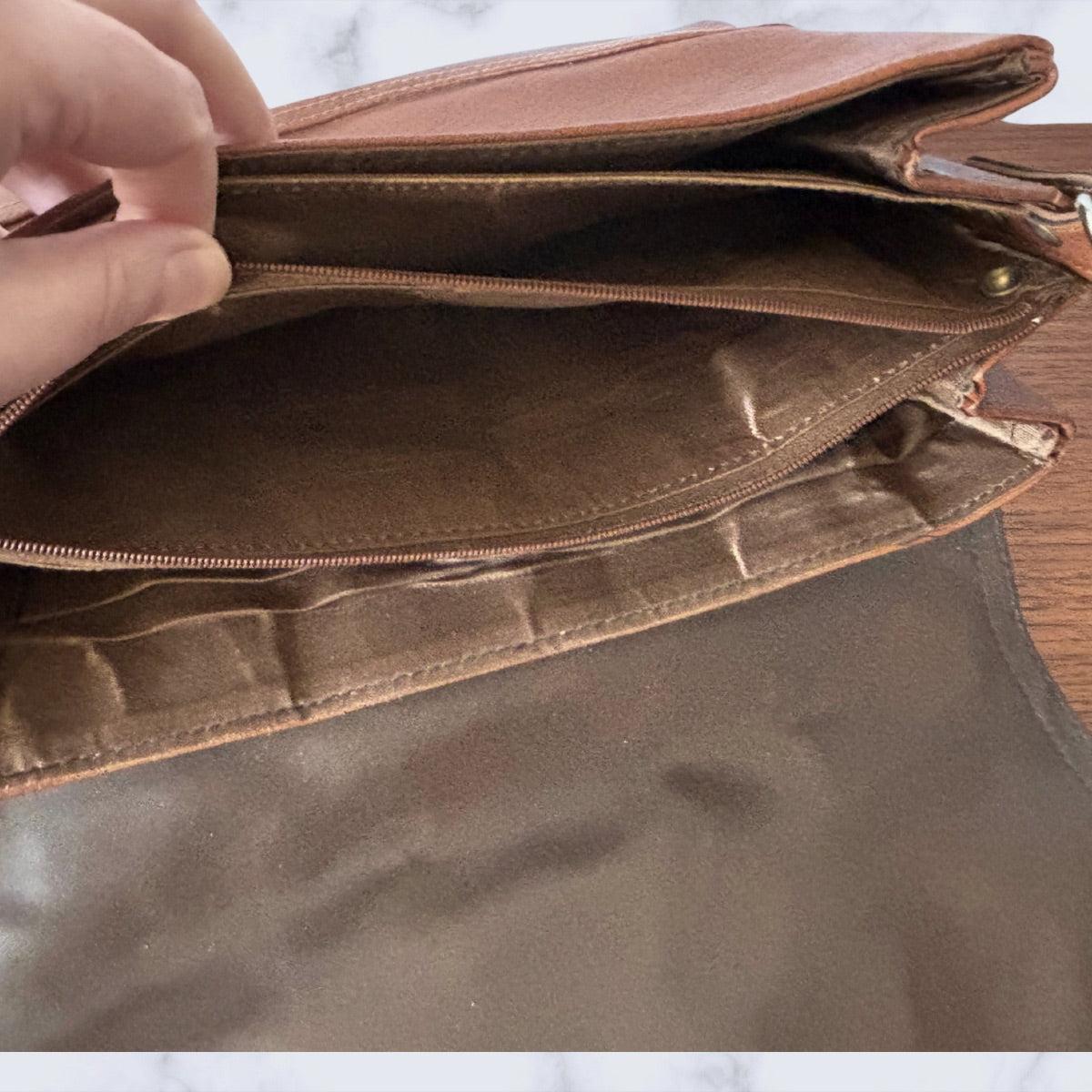 Brown  bag with a hand opening it, showing the interior.