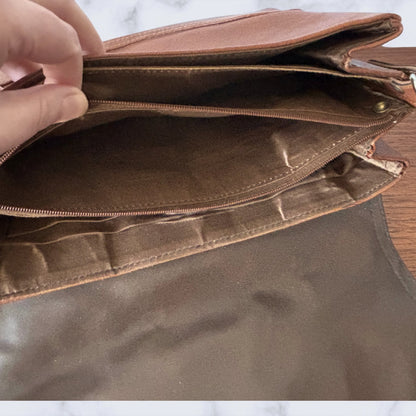 Brown  bag with a hand opening it, showing the interior.