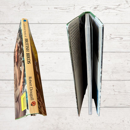 Open book showing pages with 'British Birds' by Robert Dougall on a wooden surface