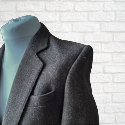 Brown jacket  on a mannequin with a white brick wall background