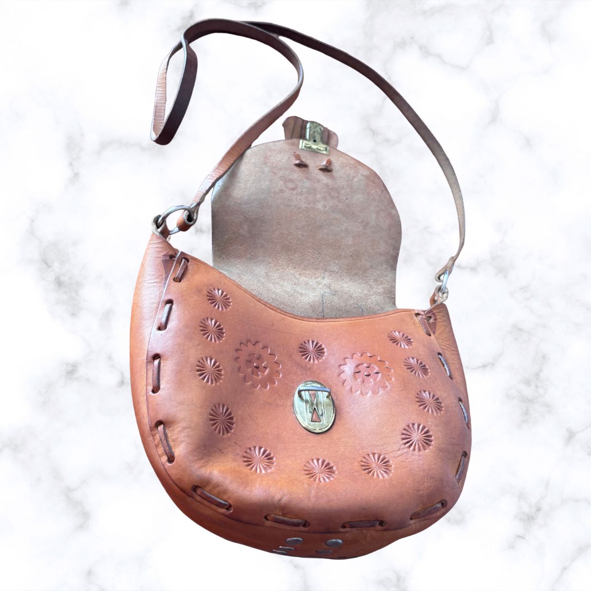 Tooled leather shoulder bag on a white background Shown open