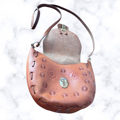 Tooled leather shoulder bag on a white background Shown open