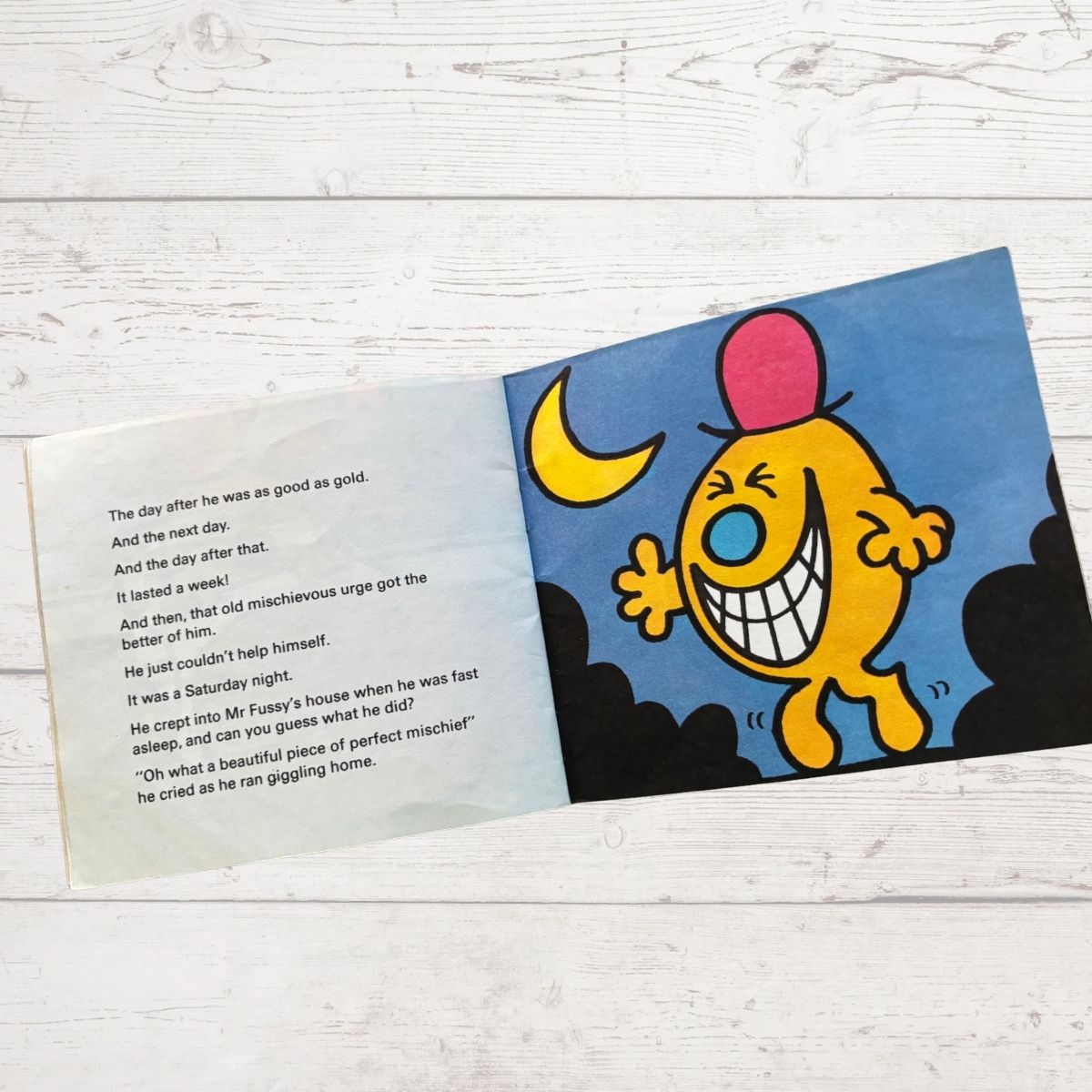 Children's book page with a cartoon character on a wooden surface