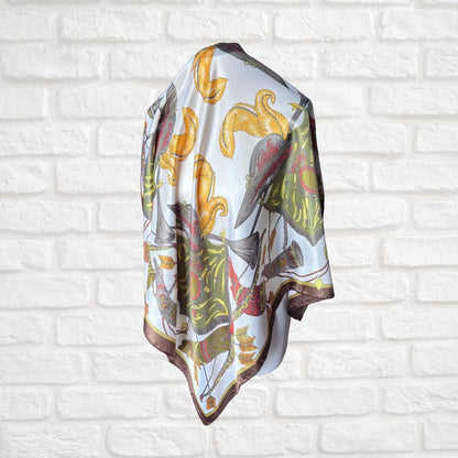 Decorative scarf with floral pattern draped over a white brick wall