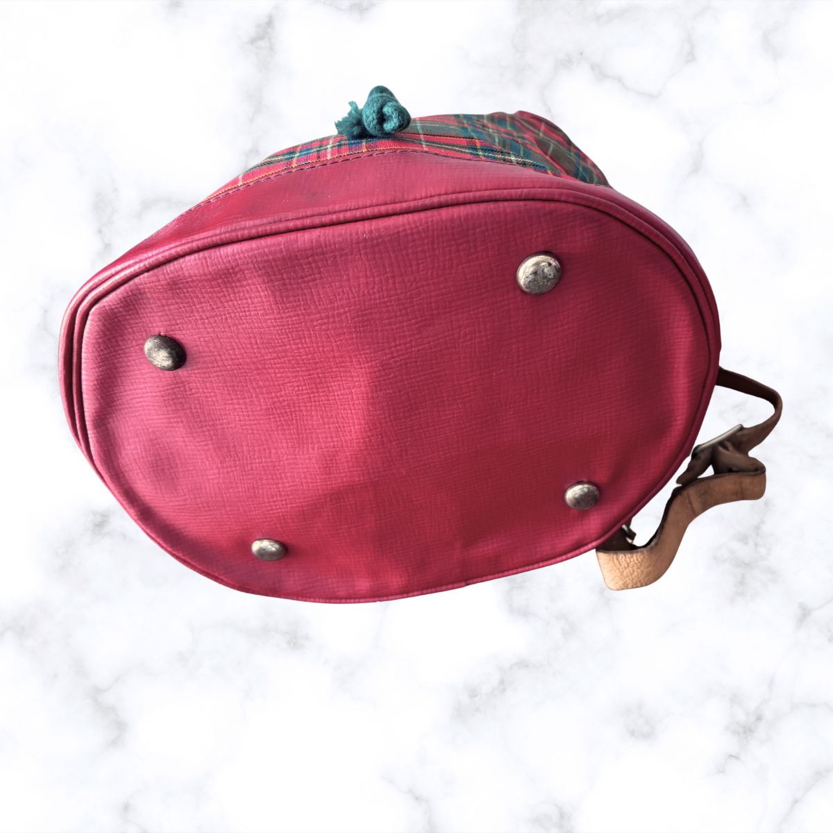 Red plaid bag with metal studs on a white marble background