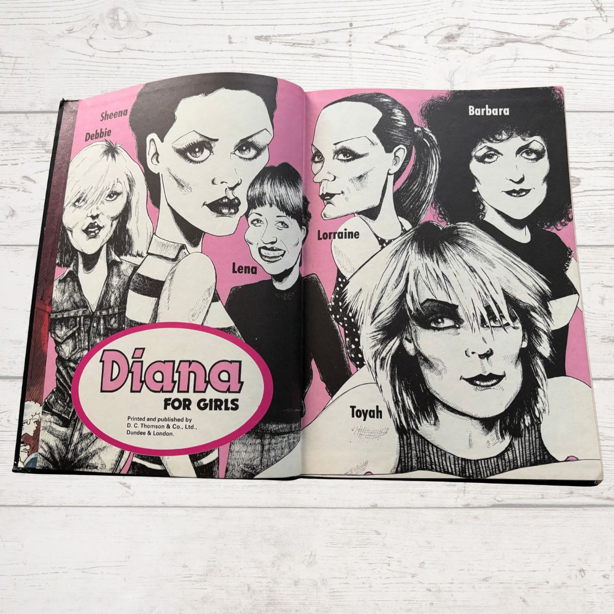 Open book with black and white illustrations of women on a pink background, featuring the brand 'Diana for Girls'.