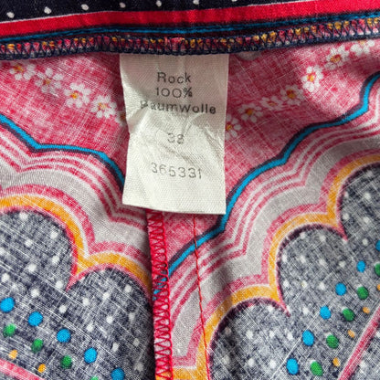 Close-up of skirt fabric with colourful patterns and a label on a red background