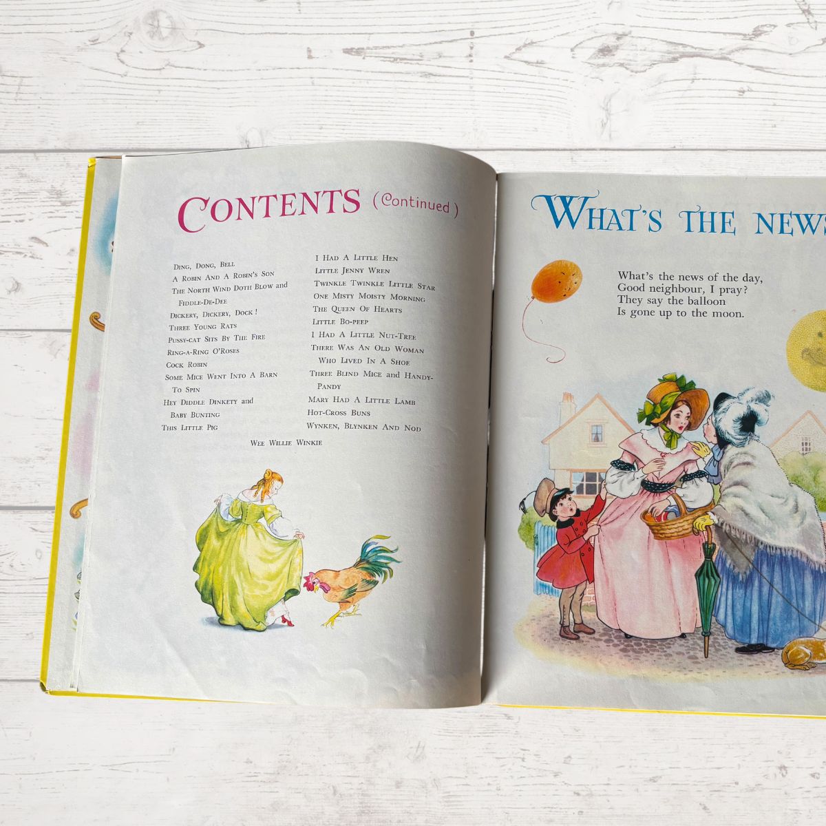 Open book with illustrated pages on a wooden surface