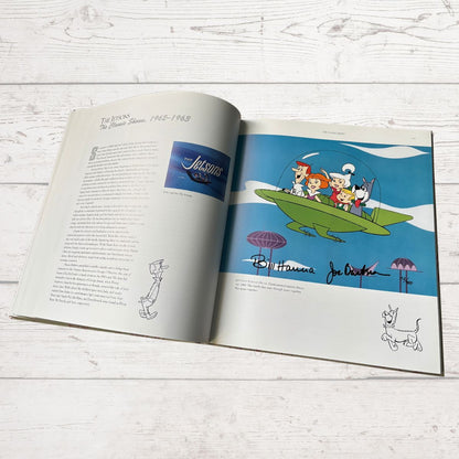 Open book with cartoon illustration of characters on a surfboard, featuring the Hanna-Barbera logo.