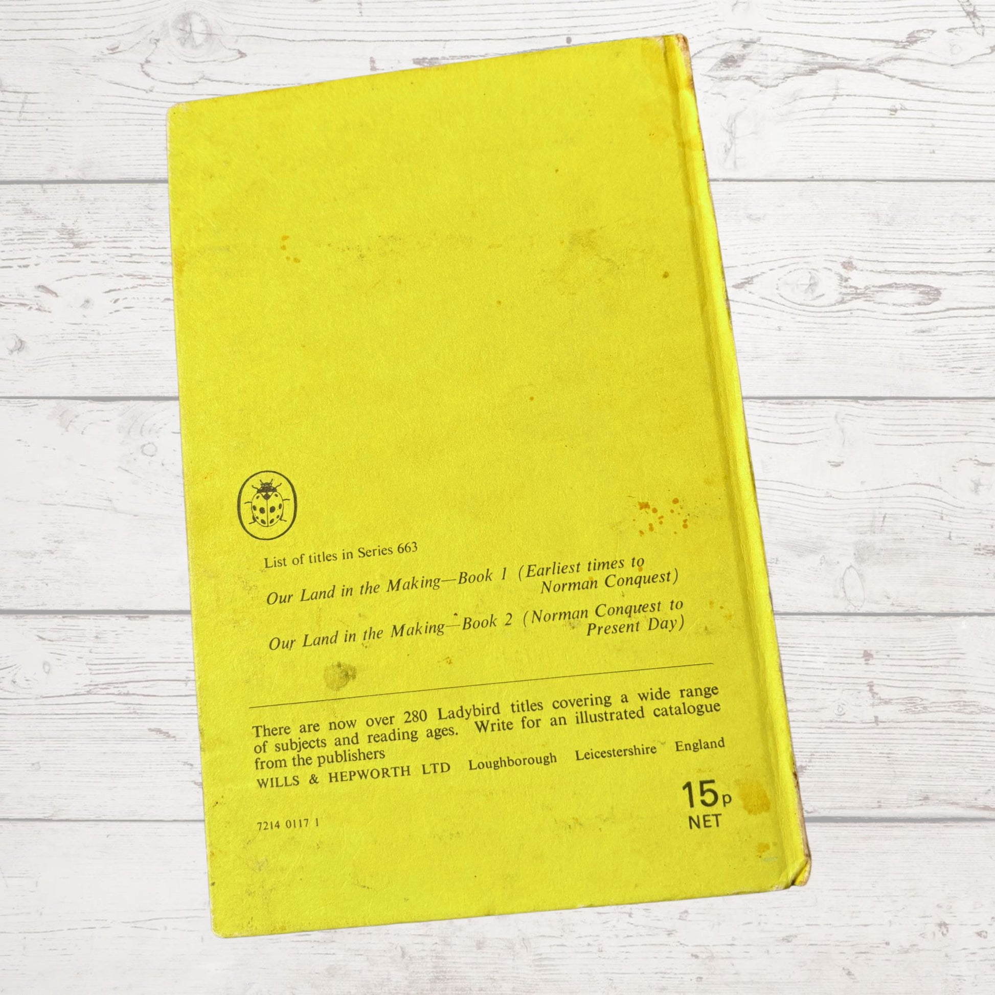 Yellow book with text on a light wooden surface
