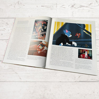 Open book on a white wooden surface with illustrations of cartoon characters.