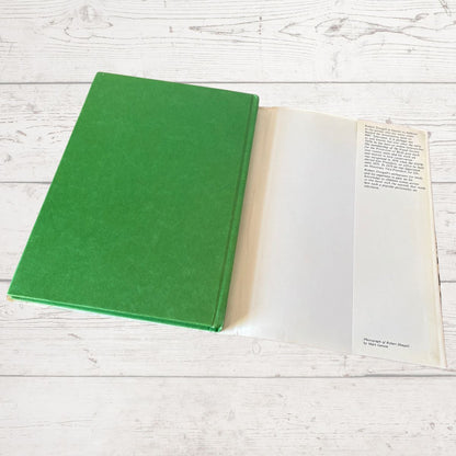 Green book on a white wooden surface