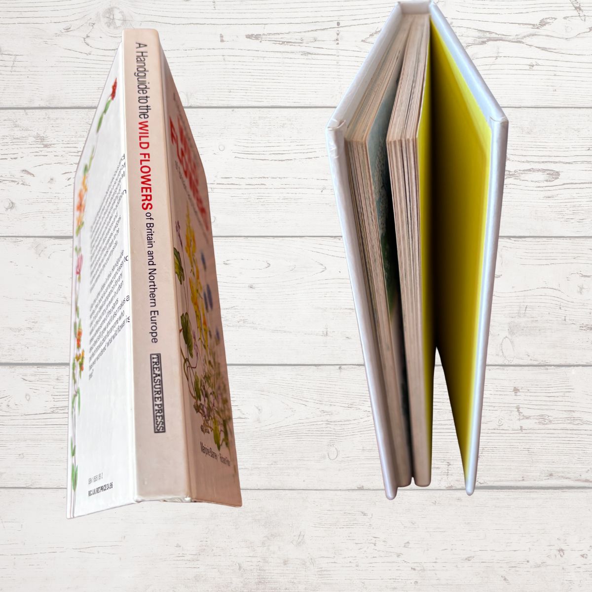 Open book with floral design on a wooden surface