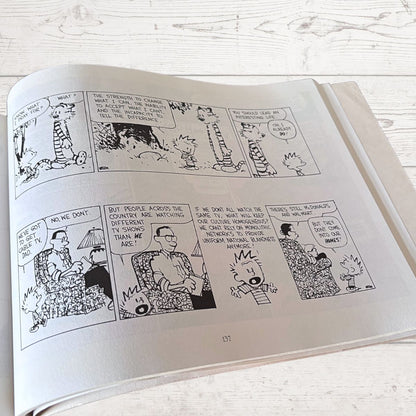 Open book with comic strip pages on a wooden surface