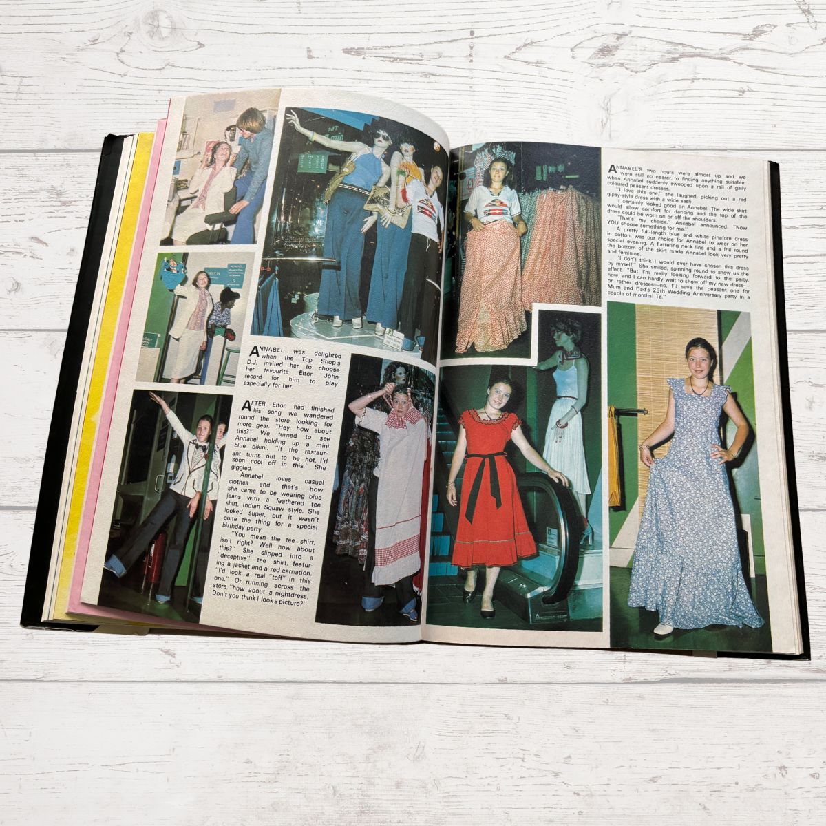 Open book with vintage fashion illustrations and text on a wooden surface