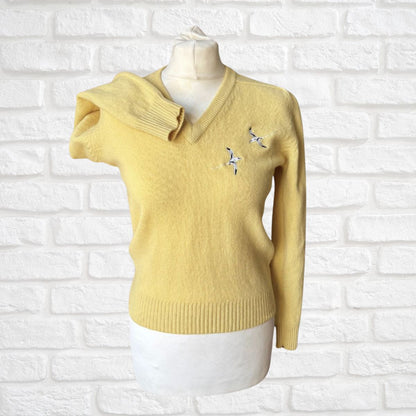 Yellow sweater on a mannequin against a white brick wall background
