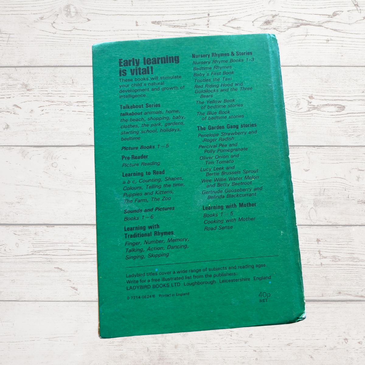 Green book with text on a light wooden surface
