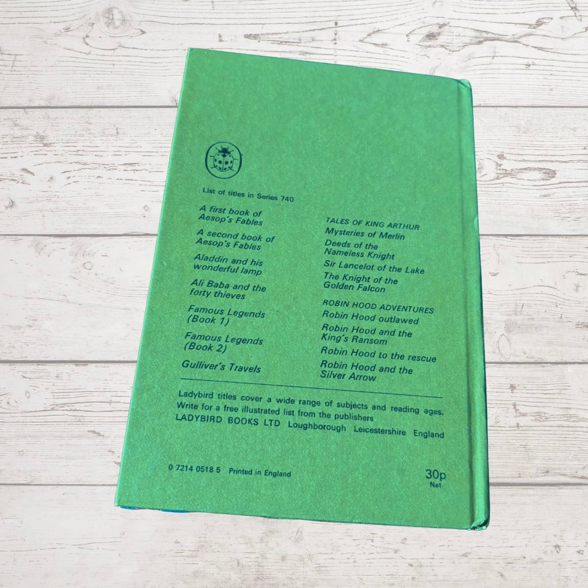A green hardcover book titled 'List of Books in Series 740' by Ladybird Books, displayed flat on a light-colored, rustic wooden background.