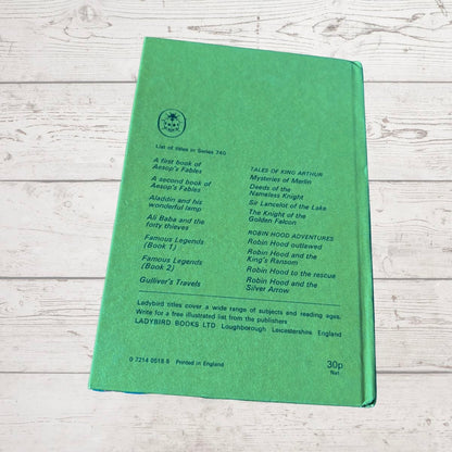 A green hardcover book titled 'List of Books in Series 740' by Ladybird Books, displayed flat on a light-colored, rustic wooden background.