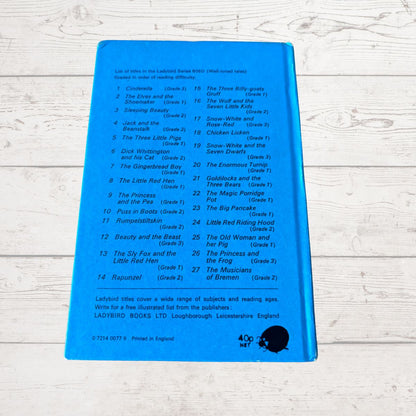 A blue back cover of a Ladybird Books children's book showing a printed list of included Little Birds series titles, photographed on a white painted wood surface.