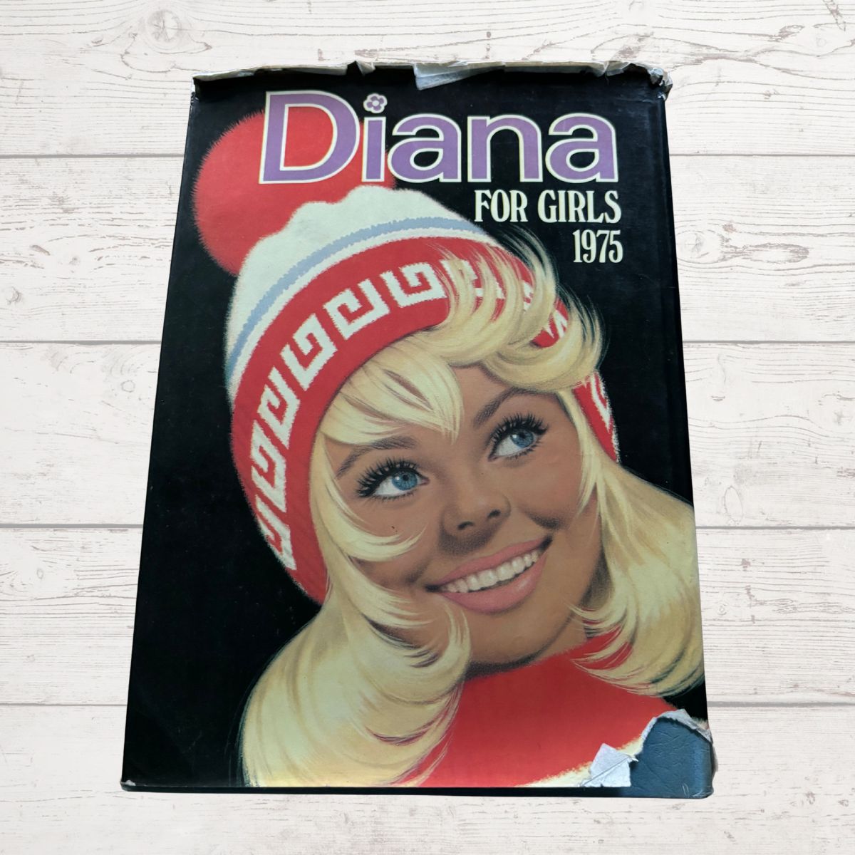 Vintage Diana Annual 1975 on a white wood background 