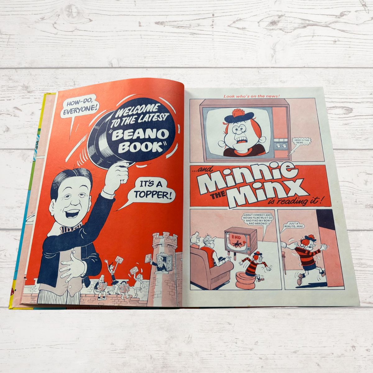 Open comic book with 'Beano' branding on a wooden surface