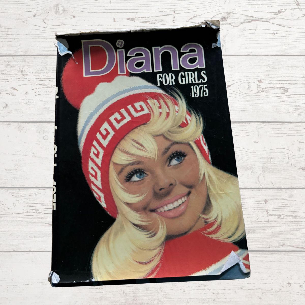 Vintage Diana Annual 1975 on a white wood background 