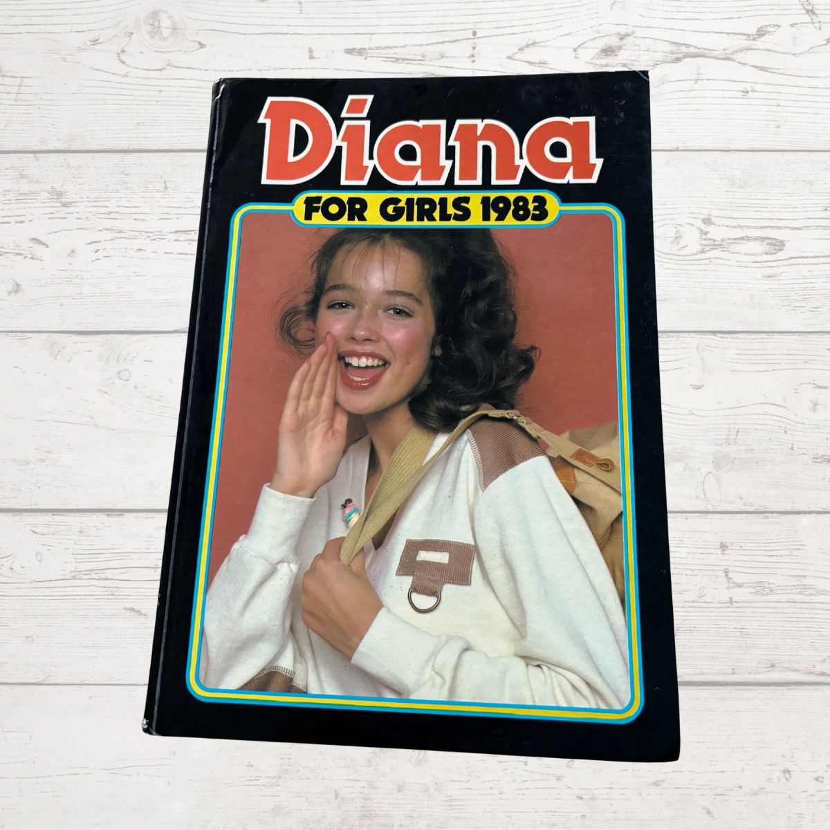 Book cover titled 'Diana for Girls 1983' featuring a girl with a backpack on a wooden surface.
