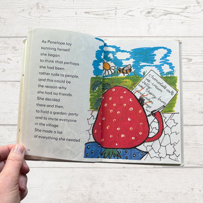 Colourfully illustrated childrens book featuring a strawberry on a white surface 