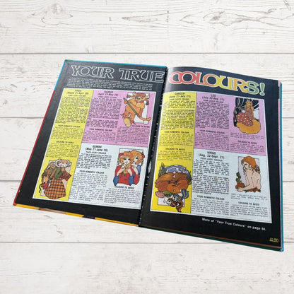 Open book showing pages with colorful illustrations and text on a light wooden surface