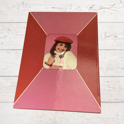 Red frame with a smaller inset photo of a woman on a wooden surface