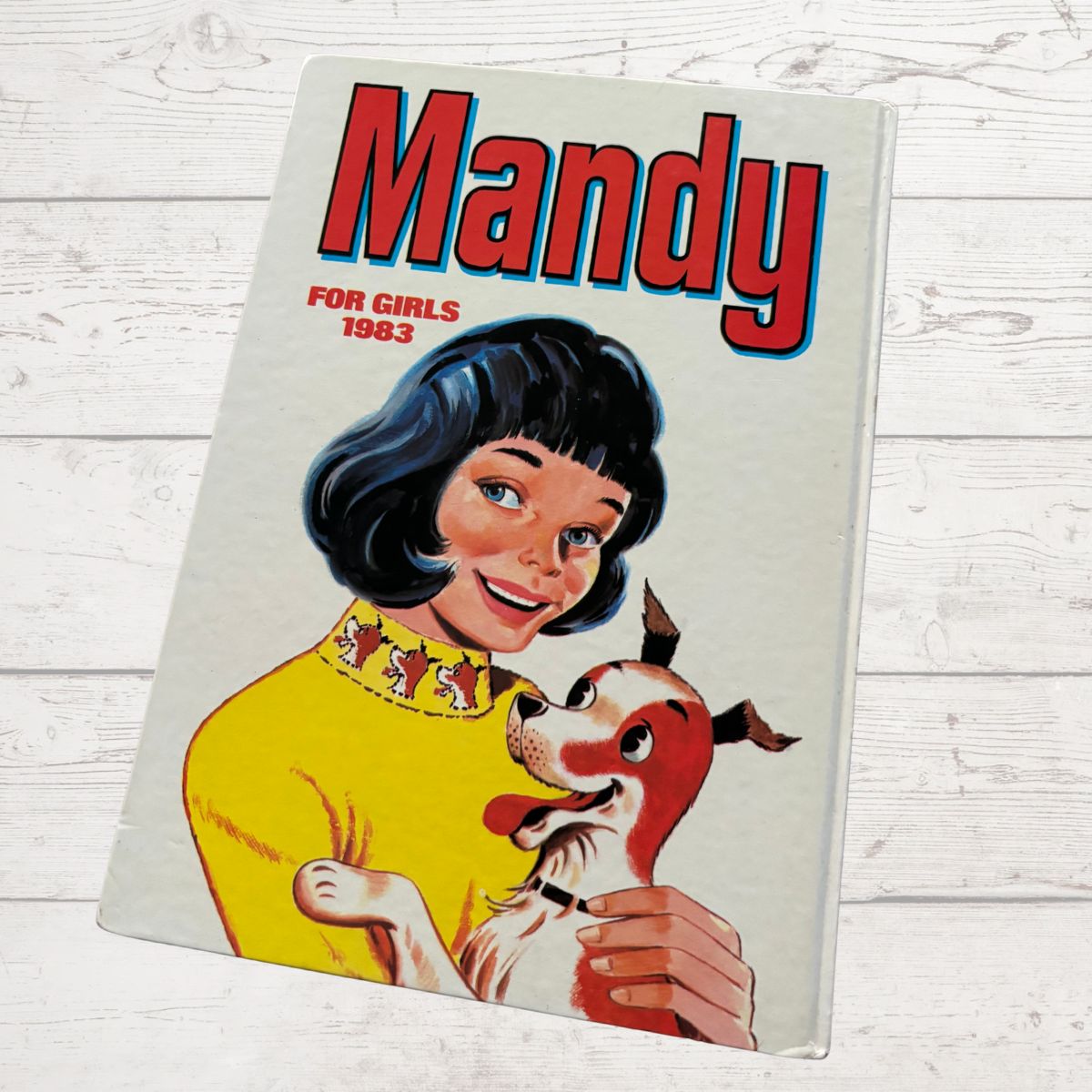 Vintage 'Mandy' magazine cover from 1983 featuring a girl with a dog on a light wooden background