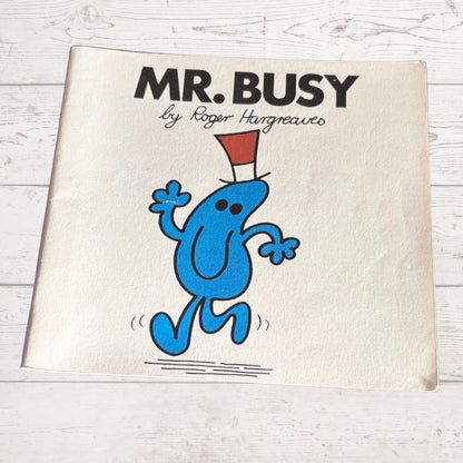 Book cover of 'Mr. Busy' by Roger Hargreaves on a light wooden surface